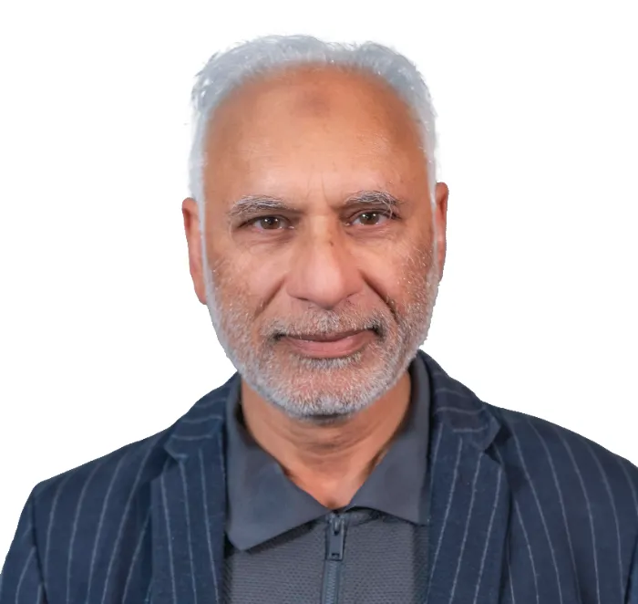 An older man with short white hair and a trimmed white beard wears a dark pinstripe blazer over a gray collared shirt. He is facing forward and smiling slightly. The background is plain white.