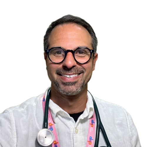 A smiling man with short dark hair, glasses, and a beard, wearing a white shirt and a stethoscope around his neck. The lanyard is pink with colorful logos. The background is plain and light-colored.