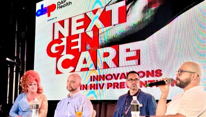 Four panelists sit on stage in front of a large screen reading “NEXT GEN CARE: Innovations in HIV Prevention.” One person, holding a microphone, speaks while the others listen. Logos for DAP Health and sponsors are visible in the top left corner of the screen.