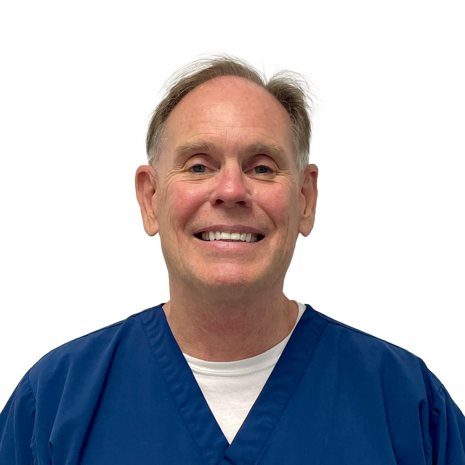 A middle-aged man with short light brown hair smiles at the camera. He is wearing a blue scrub top over a white undershirt. The background is plain white, giving the image a clean and professional appearance.