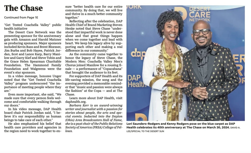 Lori Saunders-Rodgers and Kenny Rodgers, both smiling, stand together on a blue carpet in front of a step-and-repeat banner with the DAP Health logo at The Chase event celebrating DAP Health’s 40th anniversary on March 30, 2024.