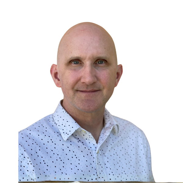A bald man with light skin and blue eyes is smiling slightly. He is wearing a white button-up shirt with a small black pattern. The background is plain white.