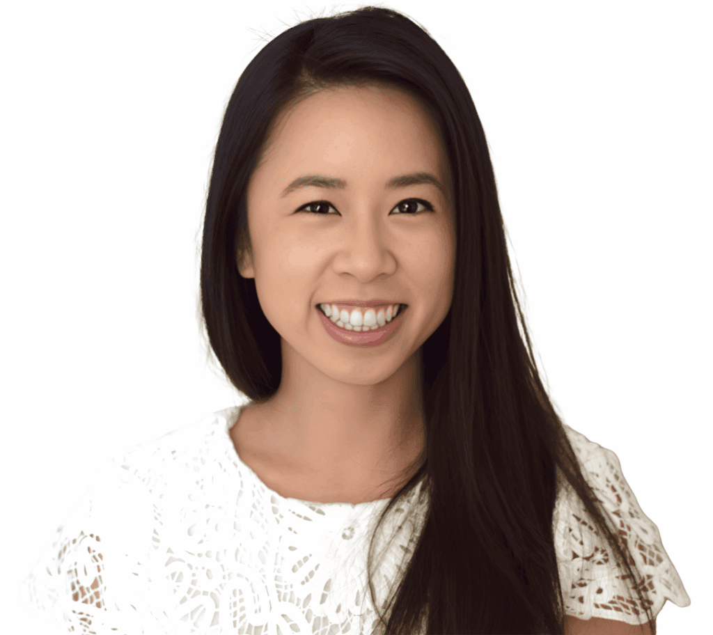 A young woman with long, straight black hair smiles at the camera. She wears a white lace top and is pictured against a plain white background. Her expression is friendly and welcoming.